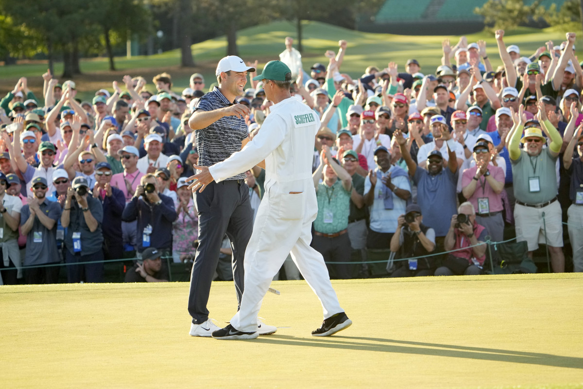 Scottie Scheffler celebrates with his caddie, Ted Scott, after finishing his round on no. 18